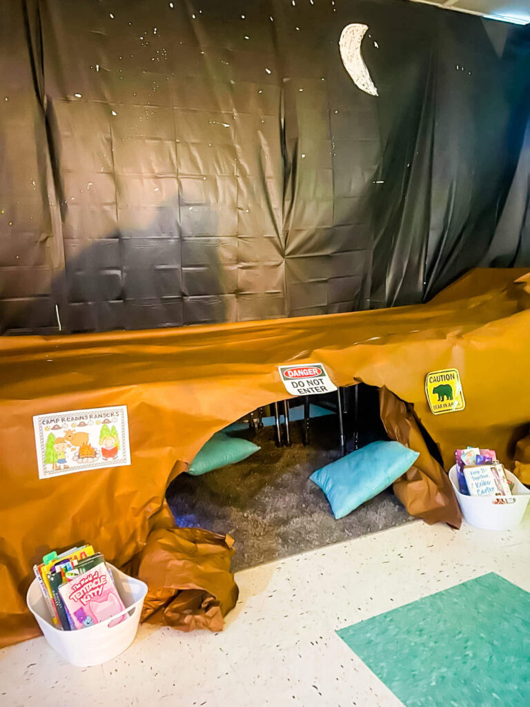Camp Read a Lot cave campsite reading station with pillows and book bins