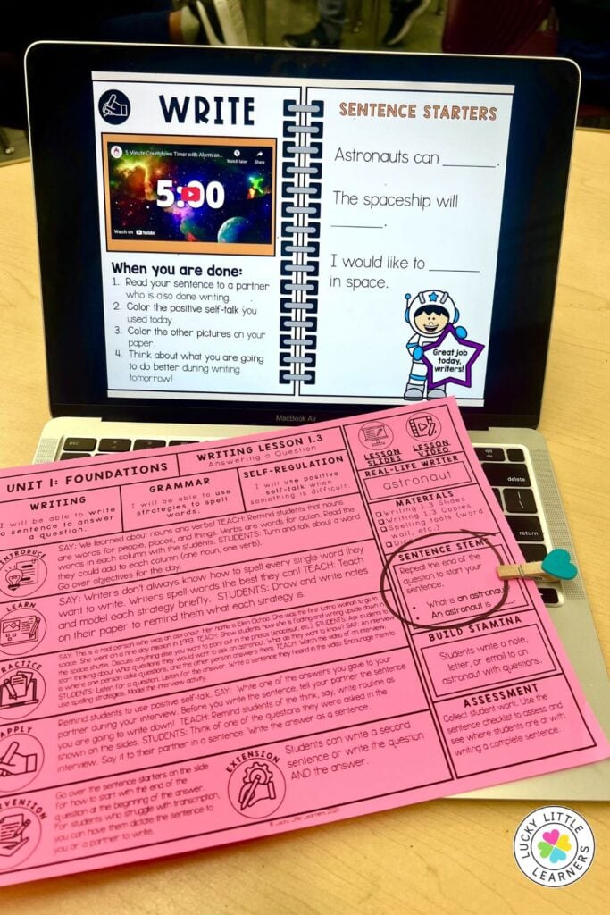 Digital writing lesson on a laptop with sentence starters and teacher guide, offering structured support and visual prompts for struggling writers.