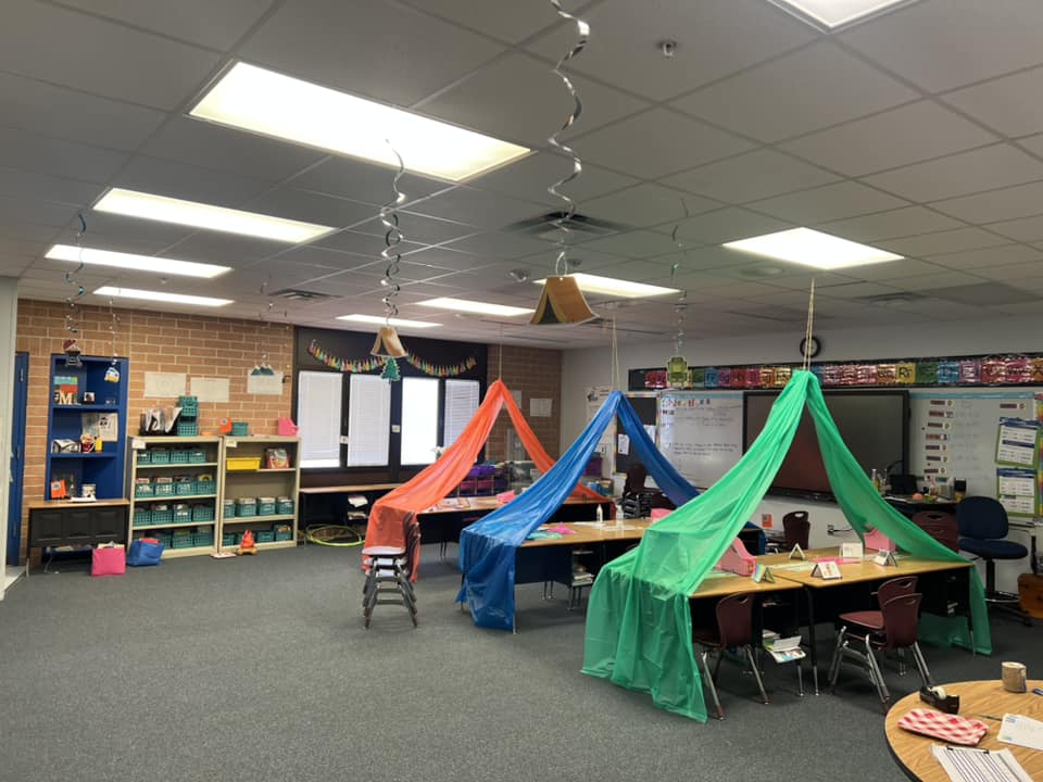 Camping and great outdoors classroom setup with fabric hanging from the ceiling to look like tents over the student desks.