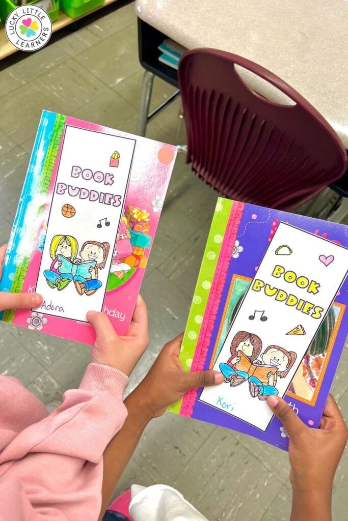 Image showing students holding decorated Book Buddies notebooks used during buddy reading activities for reflection and response.