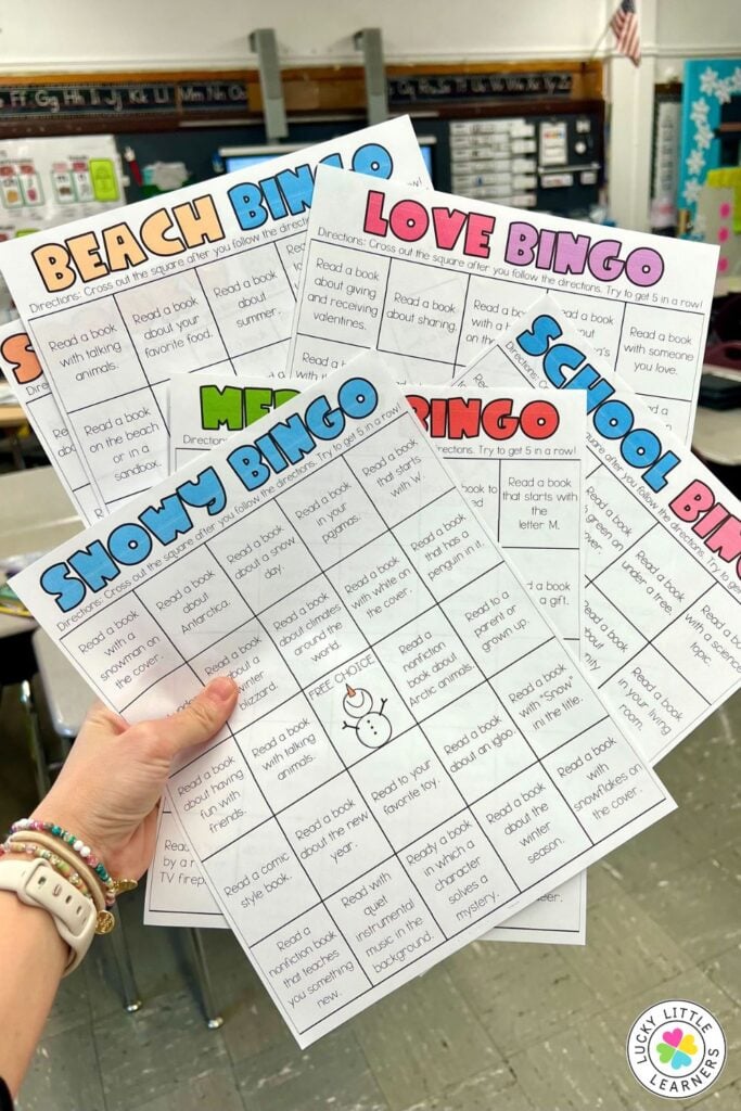 Image showing a teacher holding multiple themed reading homework BINGO boards, including seasonal and holiday reading challenges for students.